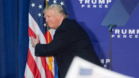 Donald Trump abraza una bandera de EEUU durante un acto de campaña en  Leesburg, Virginia. - EFE