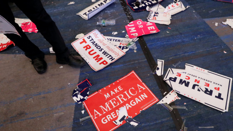 Un asistente a la fiesta del candidato republicano pasa sobre las pancartas y banderines en el suelo tras la celebración de la victoria de Donald Trump en las elecciones presidenciales en EEUU. REUTERS / Andrew Kelly