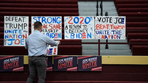 04/02/2020.-  Un hombre coloca carteles en un instituto de Iowa durante las primarias. / EFE - CRAIG LASSIG