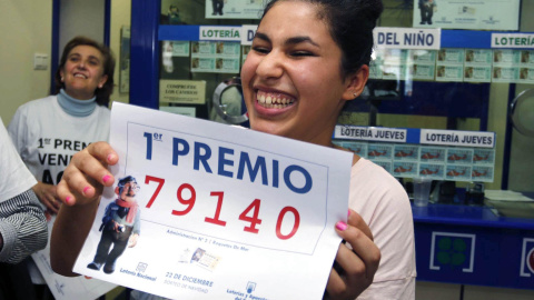 Una joven sostiene el décimo premiado en la Lotería de Navidad de 2015. / EFE