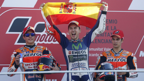 El piloto español Jorge Lorenzo (Yamaha ) en el podio junto a sus compatriotas Marc Márquez, segundo, y Dani Pedrosa, tercero, tras ganar la carrera y el mundial de Moto GP en el circuito "Ricardo Tormo" de Valencia. EFE/ Kai Forsterling