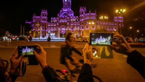 2.Varias personas fotografían la iluminación de morado del palacio de Cibeles, con motivo de la Marcha Estatal contra las Violencias Machistas. EFE/Emilio Naranjo