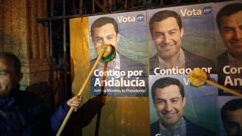 Miembros del Partido Popular (PP) pegan carteles electorales del candidato del PP a las elecciones de la región, Juan Manuel Moreno Bonilla. El lema de su candidato, "Contigo por Andalucía. Juan Manuel Moreno, tu presidente"./ REUTERS