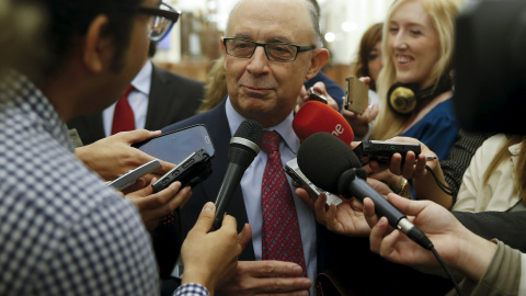 El ministro de Hacienda,  Cristóbal Montoro, rodeado de periodistas en los pasillos del Congreso, tras el último pleno de la legislatura. REUTERS/Andrea Comas