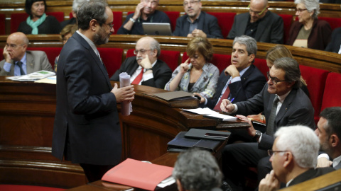 El cabeza de lista de la CUP, Antonio Baños, pasa junto al candidato de Junts pel Sí y president en funciones, Artur Mas, tras su intervención en el debate de la segunda votación de investidura tras las elecciones del 27-S. REUTERS/Albert G