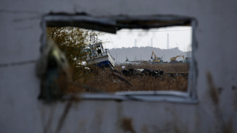 Un barco pesquero arrastrado por el tsunami del 11 de marzo de 2011, a través de la ventana de una casa abandonada en Namie./ REUTERS-Toru Hanai