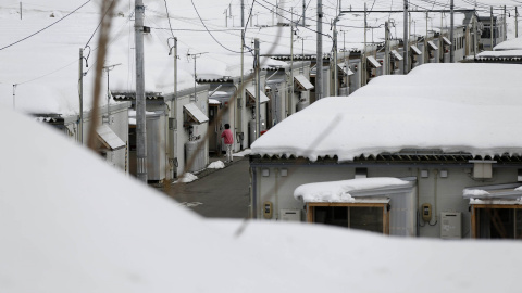 Una mujer en un complejo temporal de viviendas cubierto de nieve, que acoge a evacuados de Okuma, ciudad ubicada en la zona de exclusión junto a TEPCO./ REUTERS-Toru Hanai