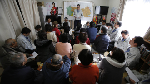 Personas que fueron evacuadas de Okuma, ciudad dentro de la zona de exclusión junto a la planta de TEPCO, asisten a una reunión con su alcalde Toshitsuna Watanabe, en el complejo temporal de viviendas que habitan en Aizuwakamatsu./ REUTERS-