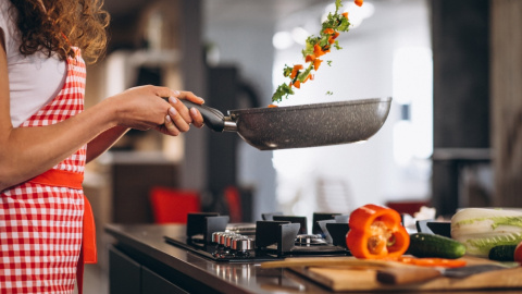 Mujer cocinando en casa. 