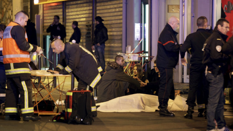 El personal de servicios de rescate trabajan cerca de los cuerpos cubiertos fuera de un restaurante después de un tiroteo en París, Francia, 13 de noviembre de 2015. REUTERS / Philippe Wojazer