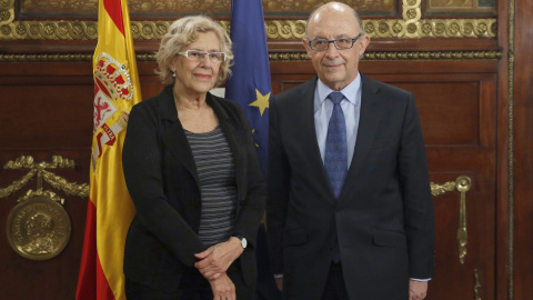 La alcaldesa de Madrid, Manuela Carmena, y el ministro de Hacienda, Cristóbal Montoro, antes de la reunión que han mantenido para abordar la polémica por el incumplimiento por parte del Ayuntamiento del techo de gasto establecido en la ley 