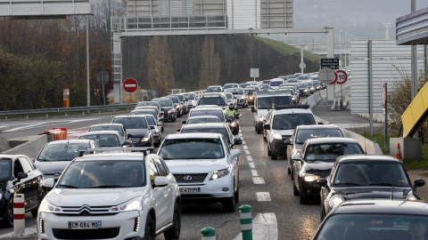 Largas colas de vehículos ante la frontera francesa mientras oficiales de Aduanas galos revisan varios vehículos en la frontera con Suiza, en Bardonnex, cerca de Ginebra (Suiza).- EFE