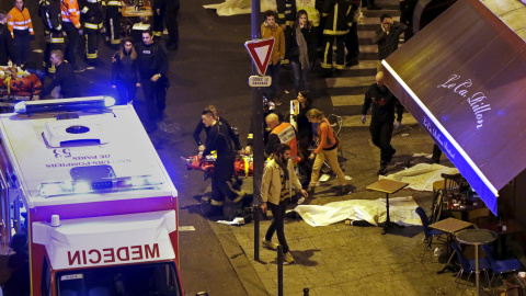 Miembros del cuerpo de bomberos parisino traslada a una ambulancia a un herido en el ataque terrorista a la sala de conciertos 'Bataclan'. REUTERS/Christian Hartmann