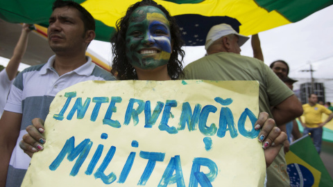 Una mujer porta una pancarta en la que pide una intervención militar durante la manifestación del pasado domingo en Manaus. - REUTERS