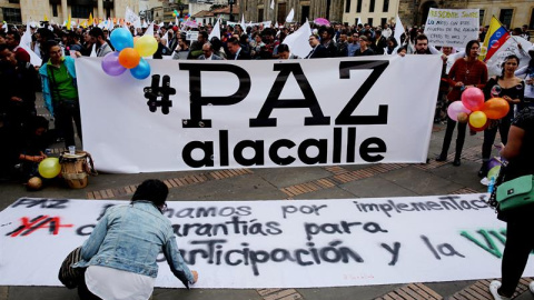 Cientos de personas se congregan en la Plaza de Bolívar para observar la firma del nuevo acuerdo de paz, que termina 52 años de conflicto armado interno, este jueves en Bogotá (Colombia). / EFE