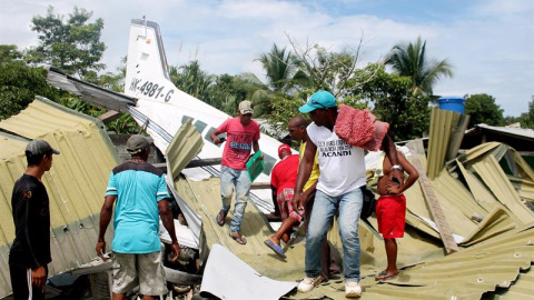 Un grupo de personas observa el lugar donde se estrelló un pequeño avión que trasladaba al equipo de béisbol del departamento colombiano de Antioquia, en los alrededores del municipio de Acandí, en la región del Chocó (oeste de Colombia). L