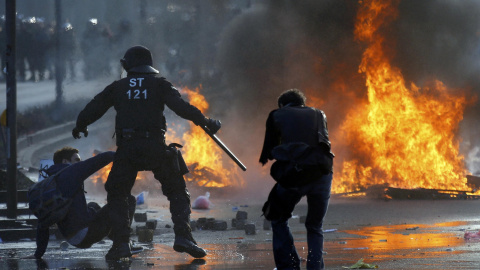 Un policía a punto de golpear con su porra a un manifestante en Fráncfort. /REUTERS