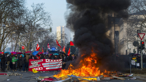 Manifestantes prenden mobiliario urbano durante una protesta ante la nueva sede del Banco Central Europeo (BCE) en Fráncfort (Alemania)./ EFE-Andreas Arnold