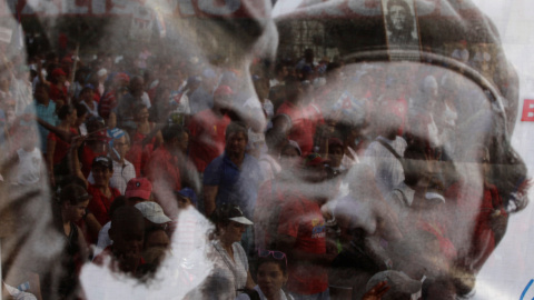 Varias personas observan un poster con la imagen de Fidel Castro y Che Guevara durante la celebración del Primero de Mayo en la Habana en 2013./REUTERS/Desmond Boylan/File Photo