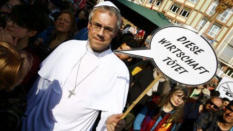 Un manifestante con una pancarta que, en alemán, dice "Esta economía mata", durante la concentración contra las políticas de austeridad en la UE realizada en el centro histórico de Fráncfort, tras la inauguración de la nueva sede del BCE. R