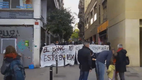 Un momento de la manifestación en la que los presentes portan pancantartas con los mensajes "el banco no está en venta" y "el Banc expropiat se queda en Gràcia". / TWITTER