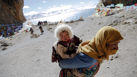 Una mujer tibetana lleva un niño en su visita a lago Namtso en la Región Autónoma del Tíbet , China 18 de noviembre de 2015. REUTERS / Damir Sagolj