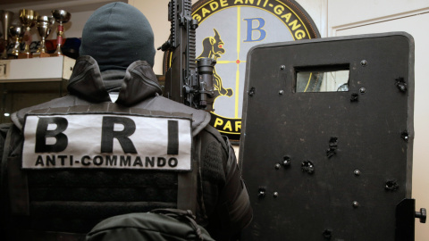 Agentes de la Policía y la Brigada de Intervención francesa (BRI) posan con el escudo, trufado de impactos de bala, que utilizaron para entrar en la sala Bataclan de París y liberar a los rehenes tomados por varios yihadistas.- AFP PHOTO / 