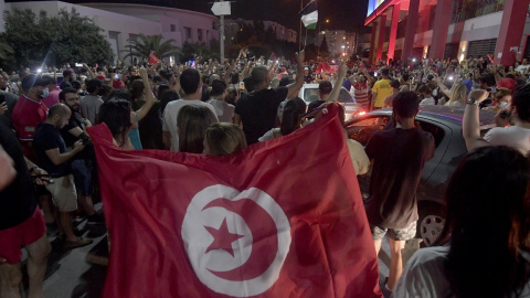 La gente celebra en las calles de Túnez después de que el presidente tunecino Kais Saied anunciara la suspensión del Parlamento y la destitución del primer ministro Hichem Mechichi, tras las protestas contra el partido gobernante. AFP/FETHI