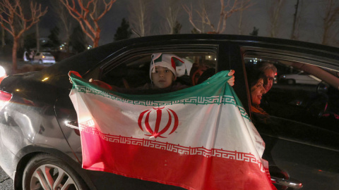  Los iraníes ondean la bandera nacional mientras celebran en la capital, Teherán, el 27 de enero de 2022, después de clasificarse para la final de la Copa del Mundo de 2022 en Qatar.- AFP