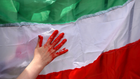 Una mujer usa pintura roja en una bandera iraní durante una protestan frente a la sede local de las Naciones Unidas en solidaridad con el pueblo iraní, en Santiago, Chile, a 11 de noviembre de 2022. -Reuters / Ivan Alvarado