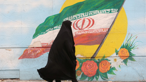 Una mujer camina junto a un mural que muestra la bandera de Irán, en Teherán, a 6 de diciembre de 2022. -Majid Asgaripour / WANA (West Asia News Agency) via REUTERS