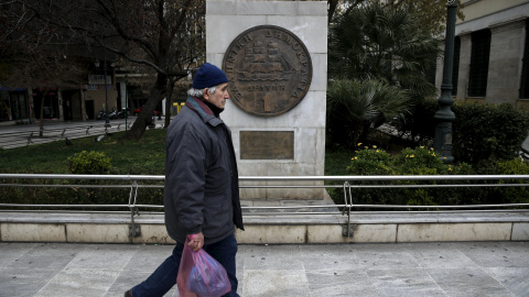 Un hombre pasa junto a una réplica de un dracma, la monedz griega antes del euro, junto al Ayuntamiento de Atenas.. REUTERS/Alkis Konstantinidis