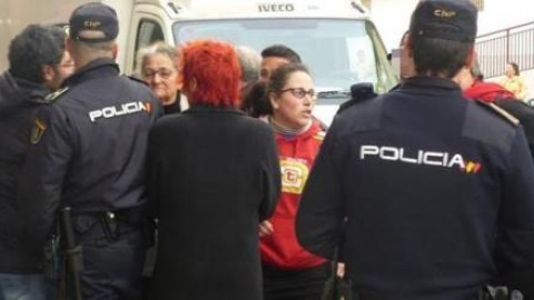 Juliana Garlito, al fondo a la izquierda, siendo detenida por la Policía tras entrar a una vivienda social vacía propiedad de la Junta de Extremadura.