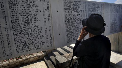 Una persona contempla la placa conmemorativa de las víctimas que las tropas nazis causaron en el pueblo de Distomo al noroeste de Atenas. - REUTERS