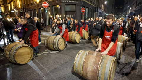 Hombres ruedan barriles de vino Beaujolais Nouveau para el lanzamiento oficial de la vendimia 2015 en el centro de Lyon. REUTERS / Robert Pratta