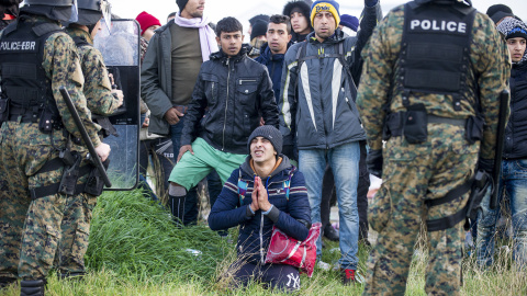 Un inmigrantes se arrodilla delante de policías macedonios, después de que intentasen cruzar la frontera cerca de Gevgelija el 26 de noviembre de 2015. AFP / ROBERT Atanasovski