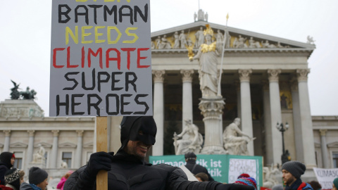 Un manifestante disfrazado de Batman en Viena delante del Parlamento austriaco lleva una pancarta que dice: "Incluso Batman necesita súper héroes del clima" . REUTERS / Leonhard Foeger