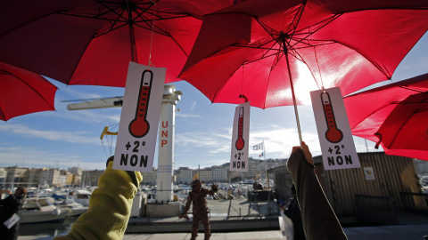 Los activistas ecologistas sujetan sombrillas de color rojo, ya que participan en una reunión simbólica, una cadena humana, después de la cancelación de una marcha climático en la capital francesa. Marsella, Francia. REUTERS / Jean-Paul Pel