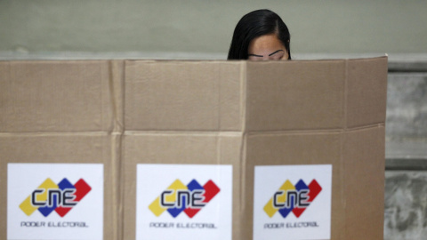 Una mujer vota en secreto en Caracas, Venezuela. REUTERS/Christian Veron