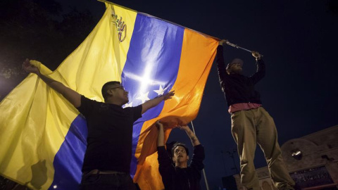 Un grupo de personas celebra la victoria obtenida por la coalición opositora Mesa de Unidad Democrática (MUD)  este lunes en Caracas./ EFE