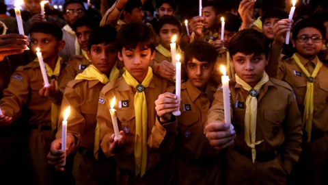 Niños sostienen antorchas durante una marcha organizada en Lahore, Pakistán, en homenaje a las víctimas del atentado talibán perpetrado en una escuela de Peshawar. Un grupo de talibanes mató a 132 estudiantes y 12 profesores tras entrar en 