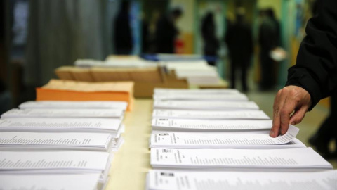 Papeletas de los diferentes partidos en el colegio electoral Repúplica de Ecuador, en Carabanchel, para los comicios generales de hoy, 20D. Los colegios electorales de la ciudad de Madrid serán los únicos de España en disponer de un sistema