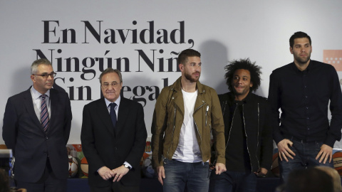 El consejero de Políticas Sociales y Familia, Carlos Izquierdo, el presidente del Real Madrid, Florentino Pérez, y los jugadores de la primera plantilla de fútbol y baloncesto, Sergio Ramos, Marcelo y Felipe Reyes, durante la presentación d