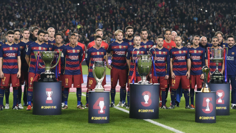 La plantilla del FC Barcelona posa con los cinco títulos conseguidos en 2015 antes del partido de Liga ant el Betis en el Nou Camp. REUTERS/Stringer