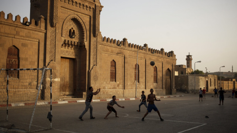 Varios niños juegas al fútbol junto a una de las entradas de la Ciudad de los Muertos, la necrópolis de El Cairo en la habitan decenas de miles de personas. REUTERS/Asmaa Waguih