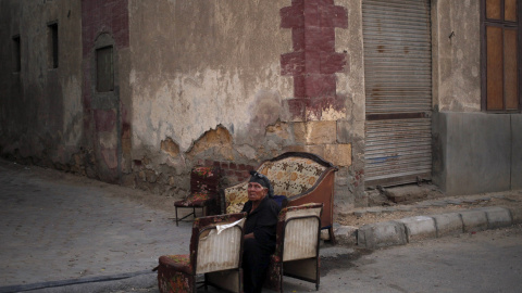 Una mujer sentada en unas sillas en uno de los callejones de la Ciudad de los Muertos, la necrópolis de El Cairo en la que residen miles de personas. REUTERS/Asmaa Waguih