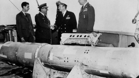 El almirante Guest estrecha la mano del general Montel junto a la cuarta bomba termonuclear rescatada del mar.