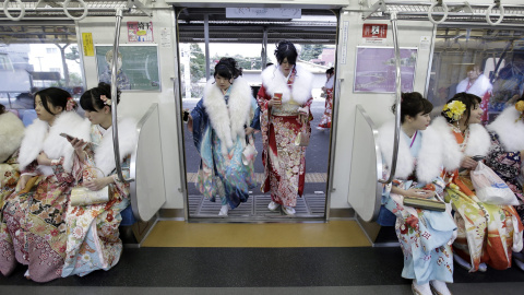 Jóvenes japonesas ataviadas con coloridos kimonos suben a un vagón de un tren tras asistir a su ceremonia de mayoría de edad en el parque de atracciones Toshimaen en Tokio. EFE/Kiyoshi Ota