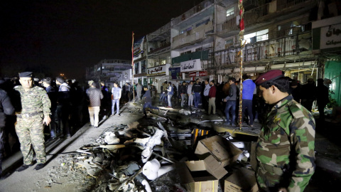 Las fuerzas de seguridad iraquíes se reúnen en el lugar donde ha estallado un coche bomba, horas antes del asalto al centro comercial en Bagdad, Irak. REUTERS/Ahmed Saad