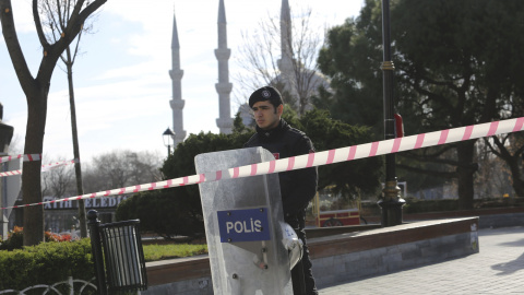 Un policia turco junto a la barrera de seguridad desplegada  cerca de la Mezquita Azul, en la plaza de Sultanahmet, la pricipal zona turística de Estambul, tras el atentado suicida que ha provocado al menos diez muertos y quince heridos. RE